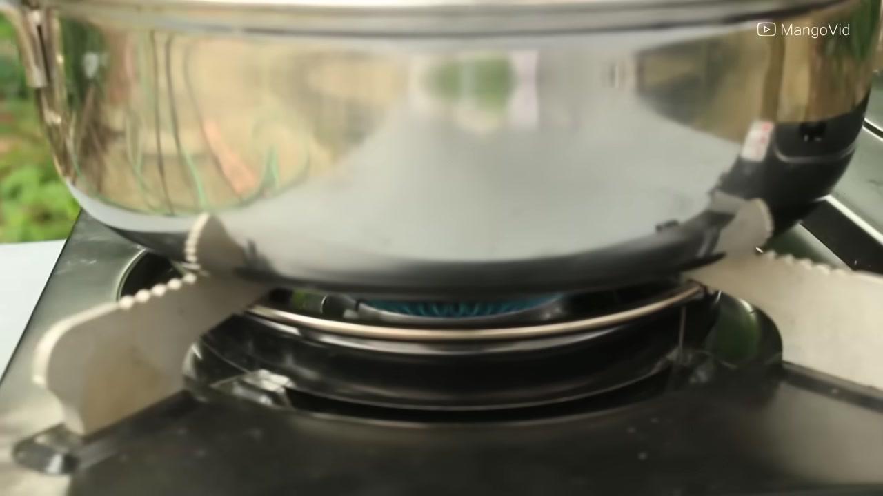 Một quả trứng được đập nhẹ nhàng vào bát chuẩn bị cho công đoạn chần.