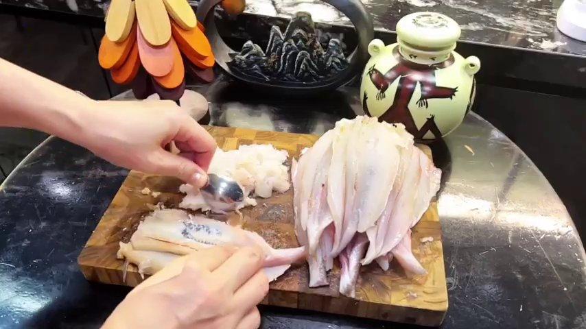 Quá trình dùng muỗng nạo thịt cá một cách khéo léo để lấy được phần thịt nguyên chất.