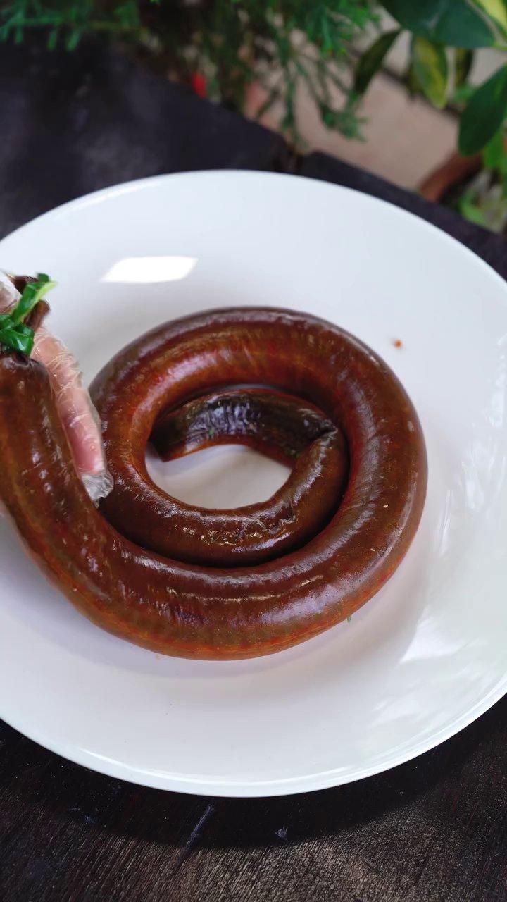 Cận cảnh công đoạn nhồi thịt lươn đã băm nhuyễn trở lại vào lớp da.