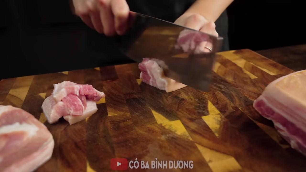 Các miếng thịt ba rọi được cắt vuông vừa ăn, dày 1cm, đang được áo đều với hỗn hợp trứng và bột năng.