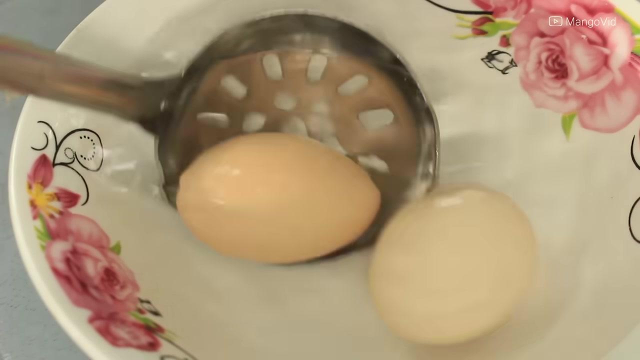 Trứng đã ngâm tương được bóc vỏ, cắt đôi và rắc hành lá, tiêu xay lên trên.