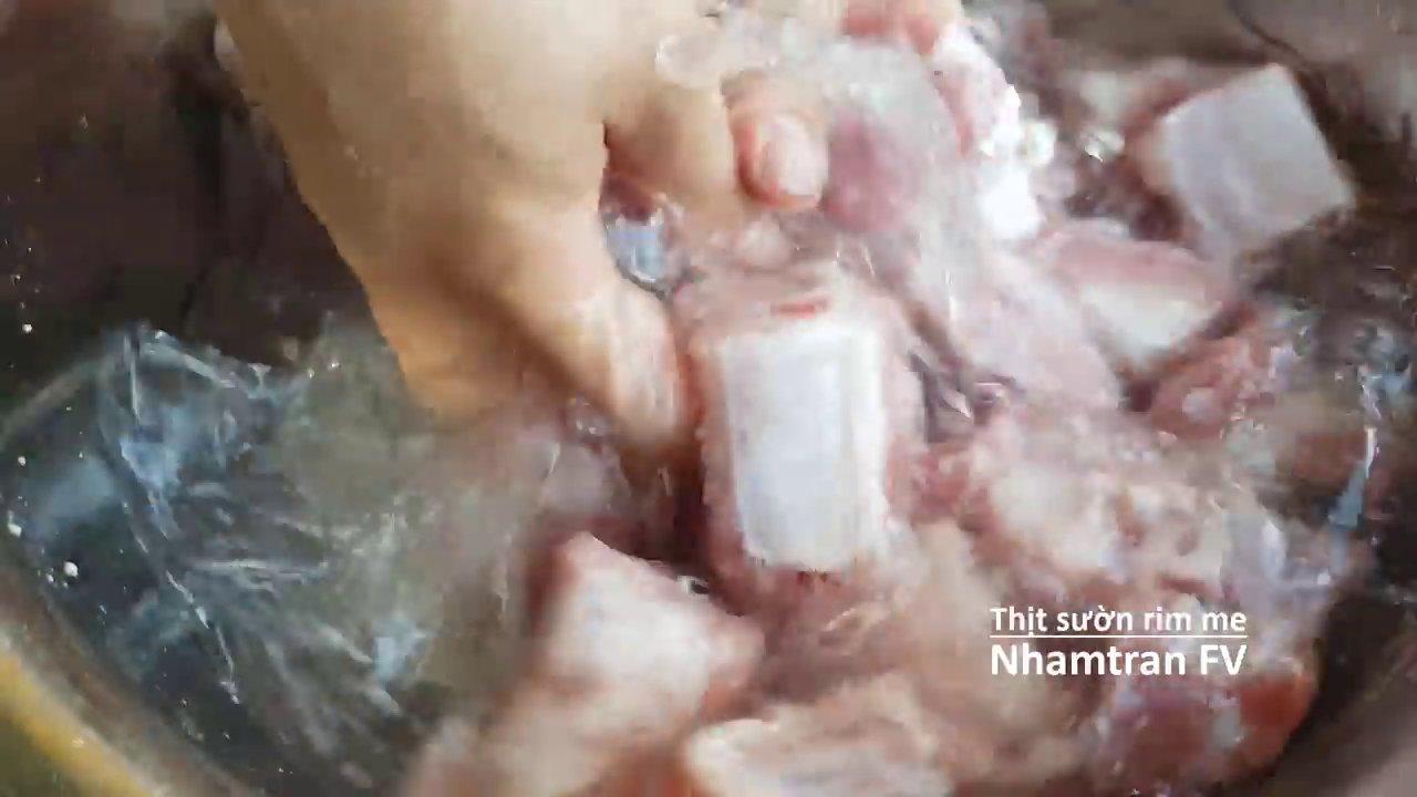 Thịt sườn sau khi chần được rửa sạch bọt bẩn trong thau nước lạnh.