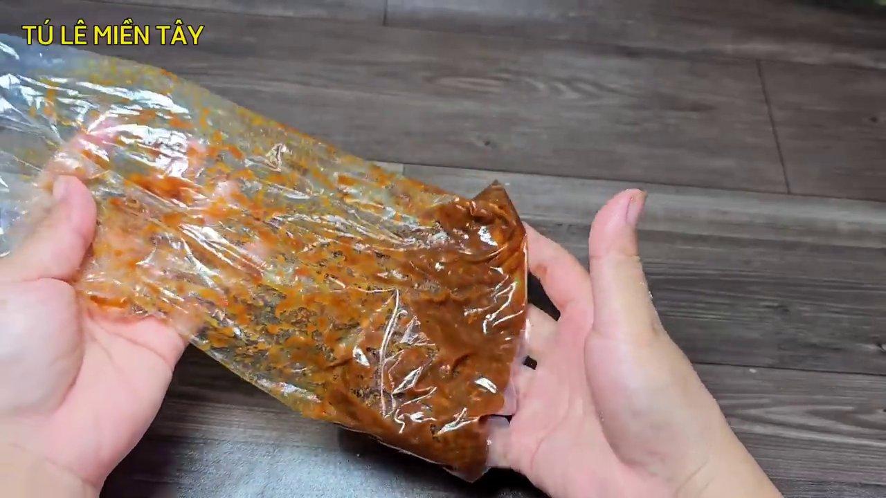 Hỗn hợp gia vị ướp chân giò với sả, tỏi, tương hột và đậu phộng được trộn đều, sẵn sàng để thấm vào thịt.