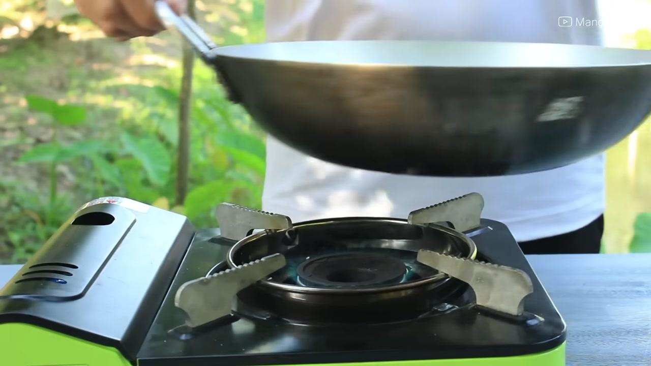 Trứng được chiên ngập trong dầu nóng, dùng muôi chan dầu lên trên để chín đều.