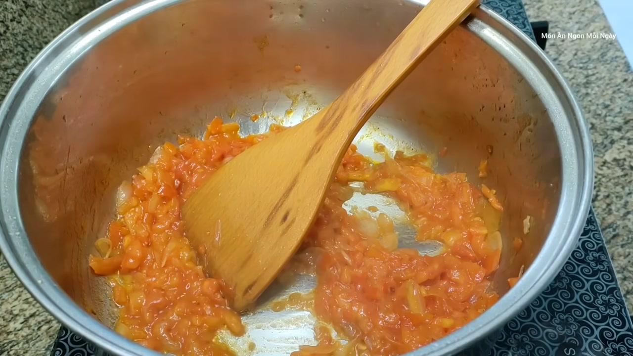 Cá điêu hồng và phần cọng rau cần đã được cho vào nồi, đang sôi lăn tăn với màu nước canh đỏ cam hấp dẫn từ tương ớt và cải chua.