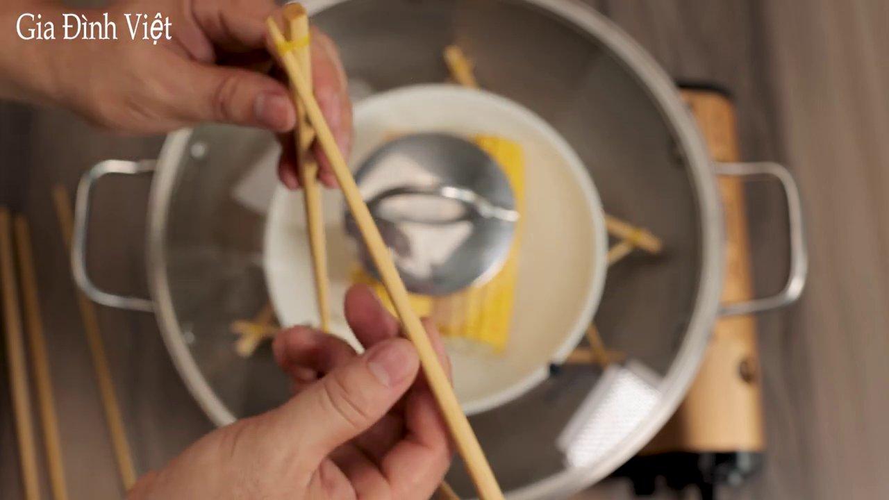 Hai khung tam giác được lồng vào và cố định bằng dây thun, tạo thành giá hấp hoàn chỉnh.