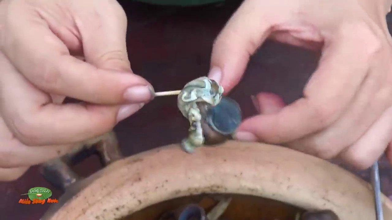 Nồi cá lóc kho tộ sôi liu riu trên bếp lửa, thịt cá săn chắc, thấm đượm gia vị.