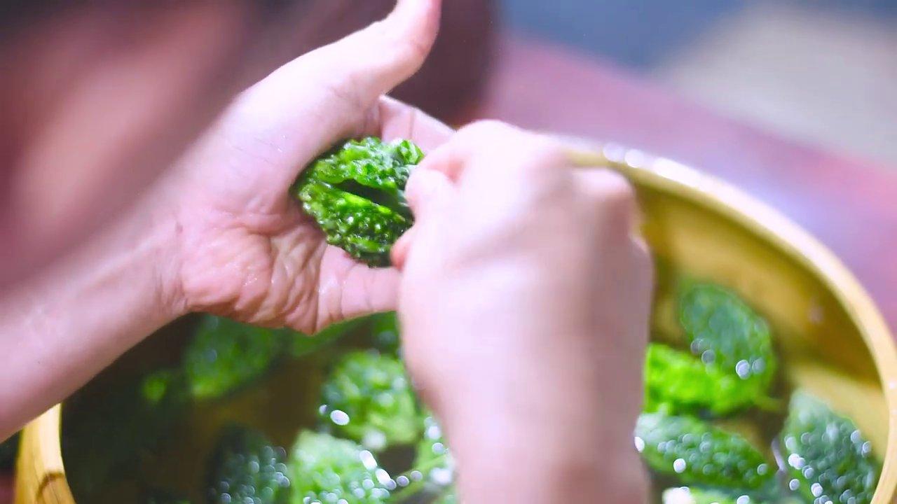 Cạo sạch vỏ và ruột khổ qua rừng một cách tỉ mỉ.