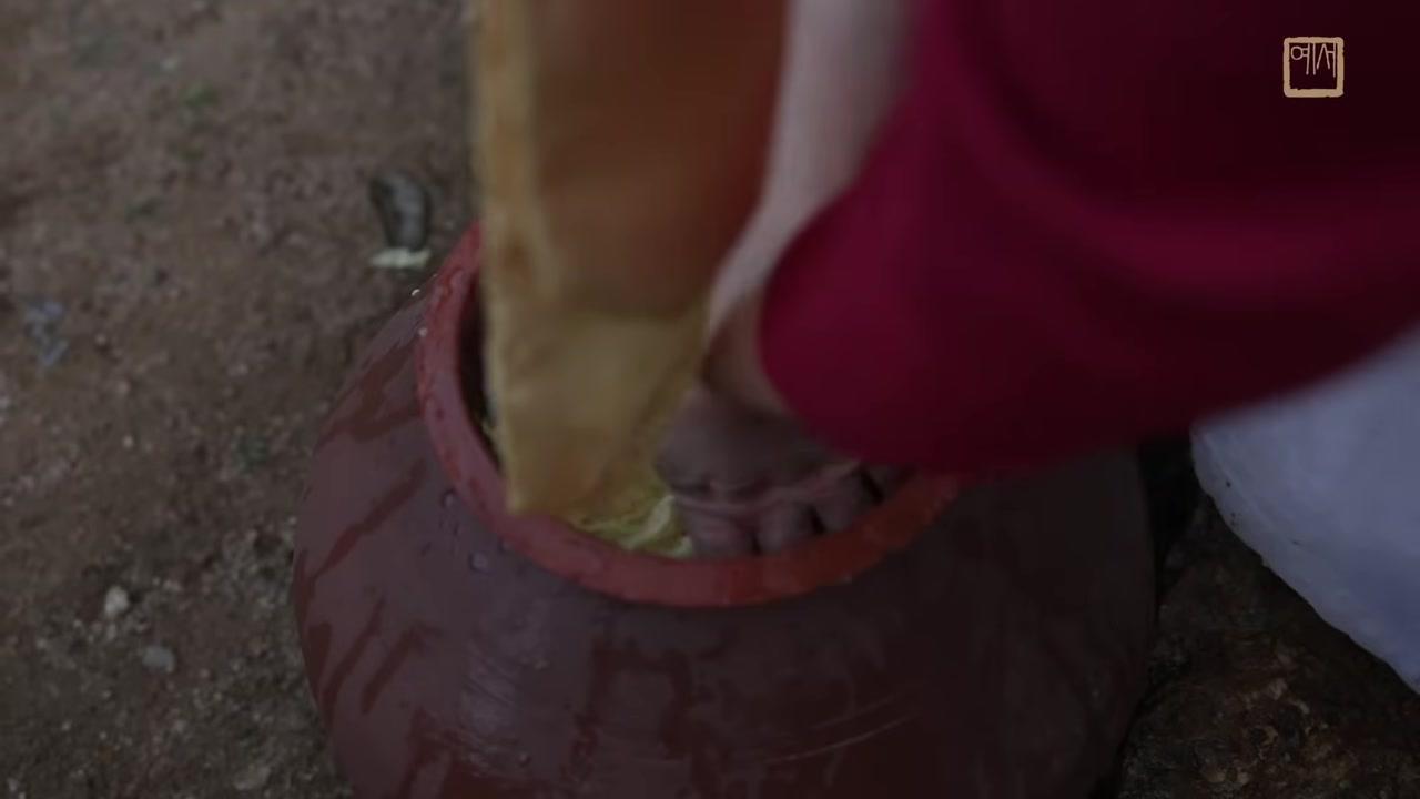 Một đĩa gỗ lớn bày biện đầy đủ các nguyên liệu: bột ớt đỏ rực, tỏi băm, gừng, hành lá, củ cải sợi, cùng các loại gia vị bí truyền khác.