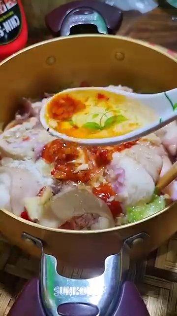 Chân giò đang được hầm trên bếp, nước sốt sôi lăn tăn.