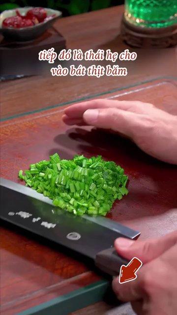 Một quả trứng gà được đập vào bát thịt xay đã trộn gia vị.