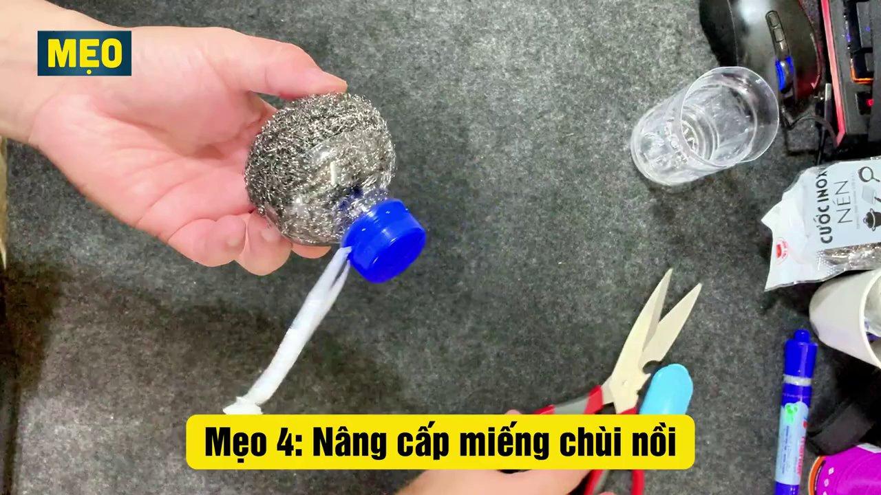 Miếng cọ nồi được gắn thêm tay cầm từ nắp chai nhựa, giúp bảo vệ tay và thao tác dễ dàng.