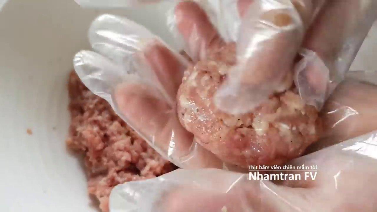 Viên thịt vàng ươm được sốt đều với nước mắm tỏi sánh quyện, rắc thêm hành lá xanh thơm.