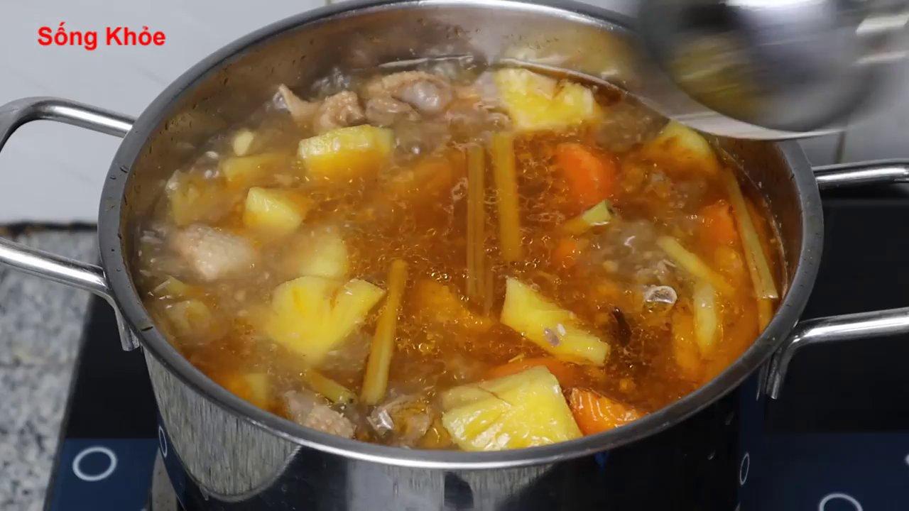 Thành phẩm nồi vịt nấu khóm nóng hổi với thịt vịt mềm thấm vị, dứa và cà rốt chín tới, điểm xuyến hành ngò thơm lừng.