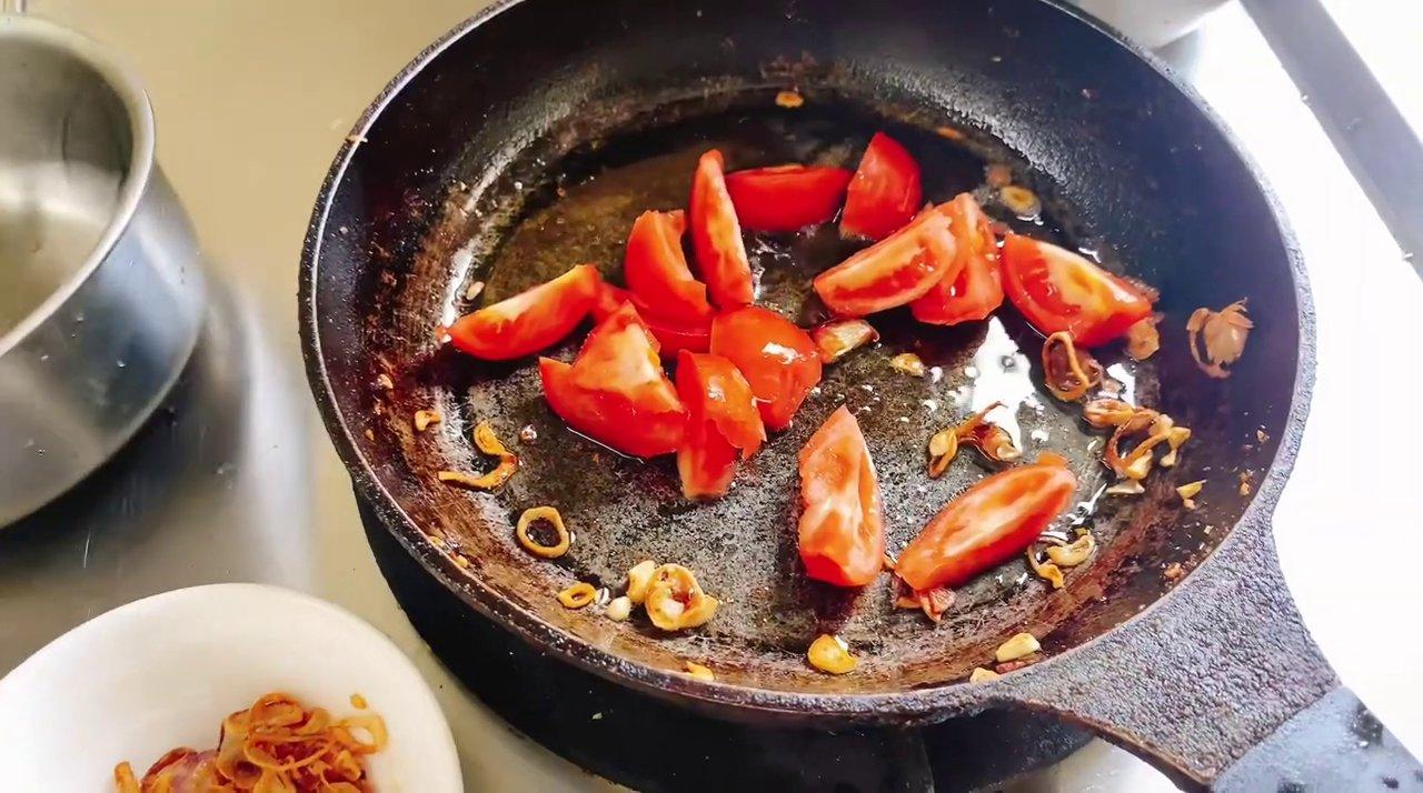 Nồi dưa cua hoàn chỉnh với màu đỏ của cà chua, vàng của gạch cua, ăn kèm rau sống.