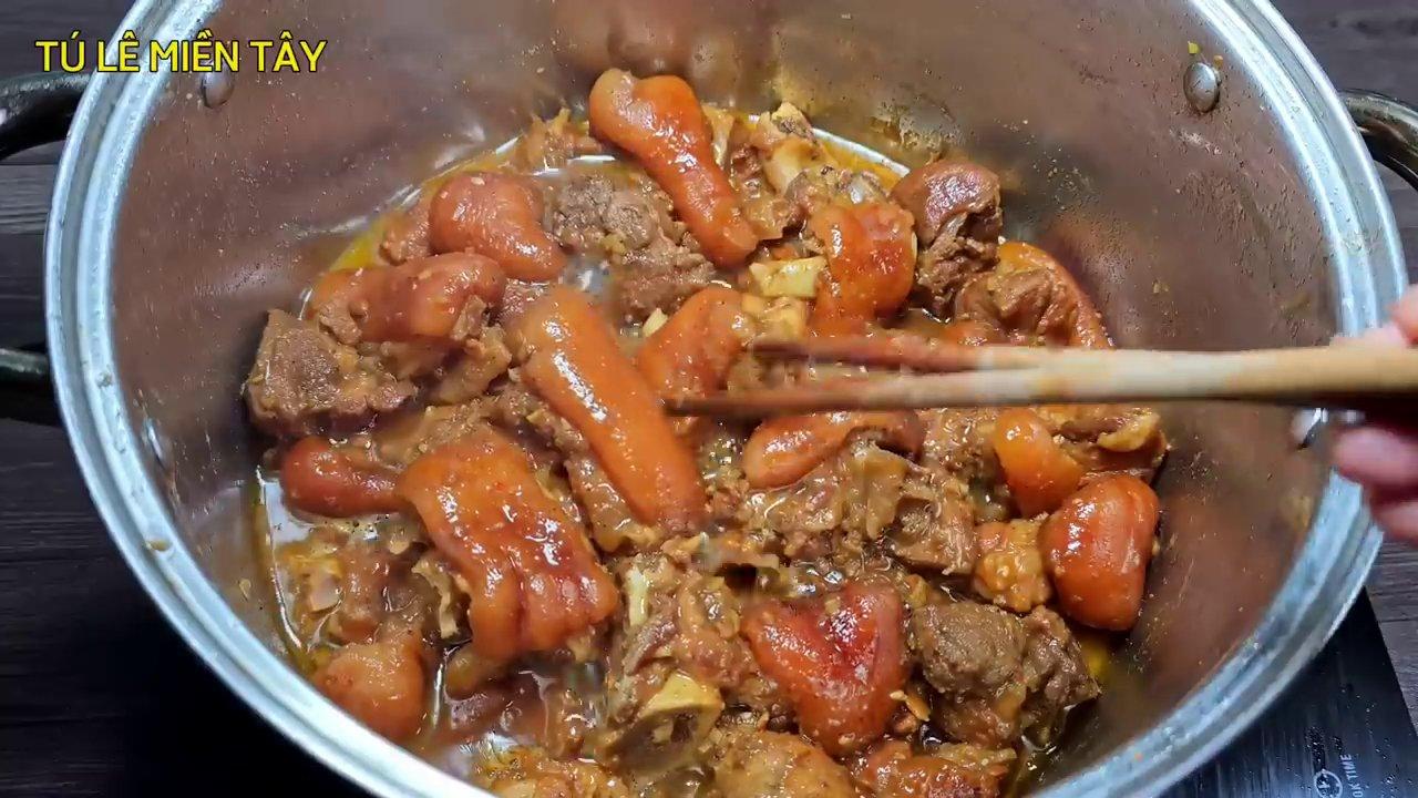 Nồi chân giò hầm nước dừa đang sôi lăn tăn, thịt đã chín mềm và ngấm đều gia vị, tỏa hương thơm nức mũi.