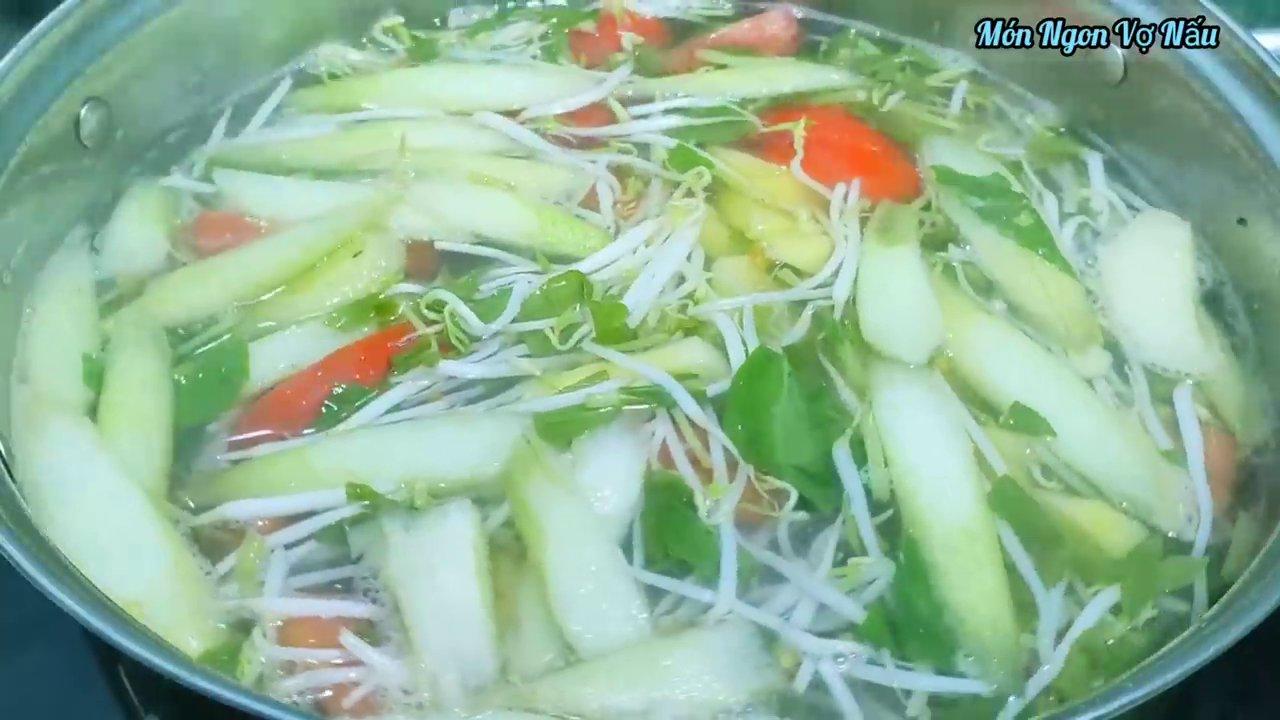 Múc canh chua cá nóng hổi ra tô, với màu sắc bắt mắt từ cà chua, đậu bắp và rau thơm.