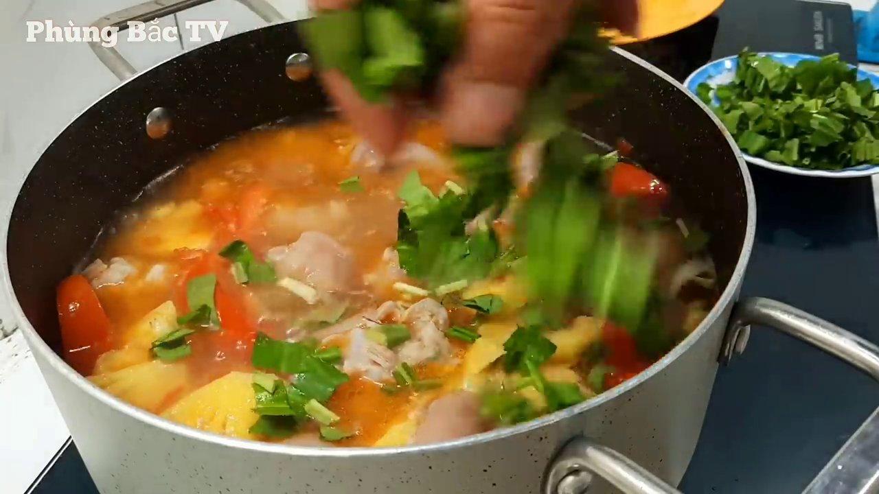 Món chân giò hầm cà chua hoàn thiện với nước lèo đỏ au, chân giò mềm ngọt và rau thơm điểm xuyết.