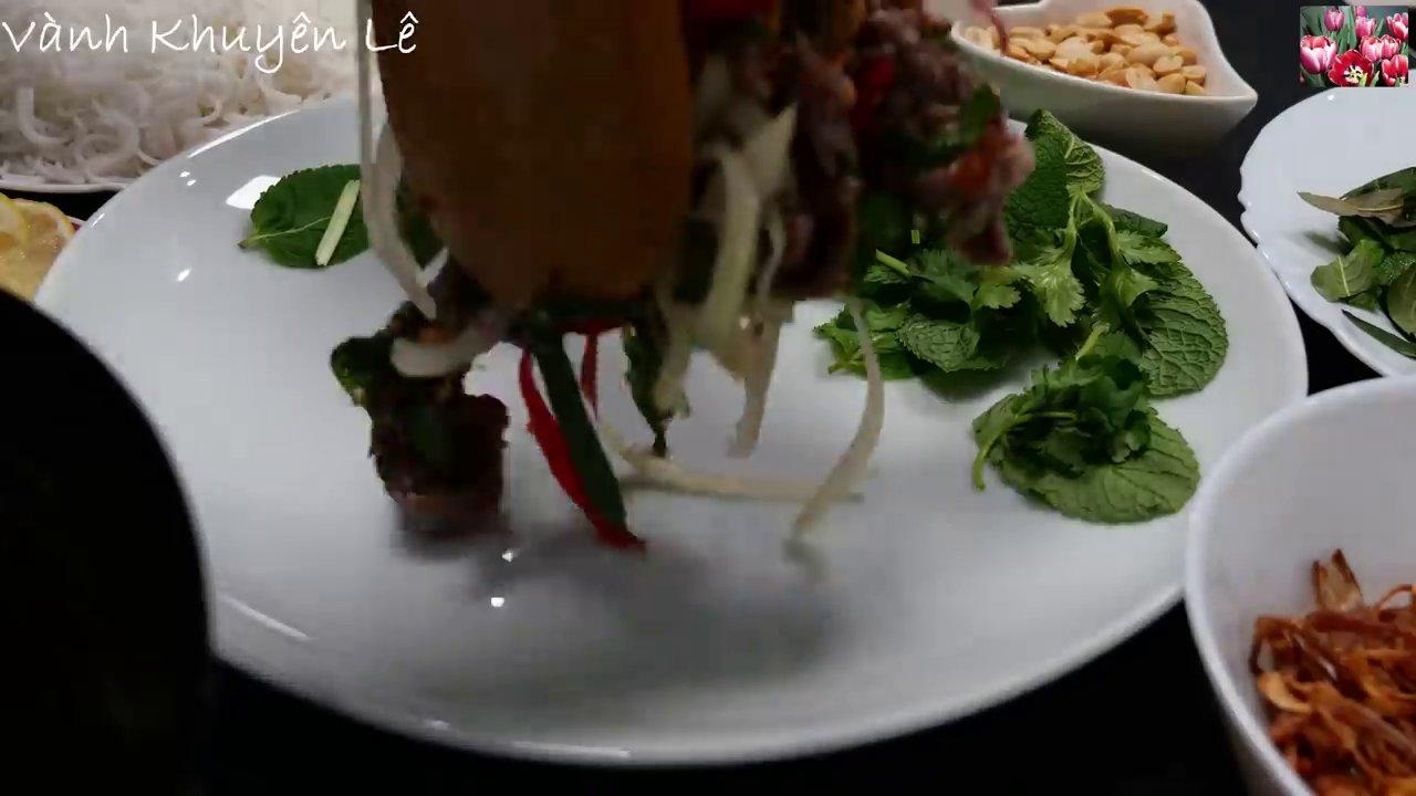 Thịt bò được trộn đều với nước mắm chua ngọt, hành tây giòn và các loại rau thơm, sẵn sàng để trình bày.