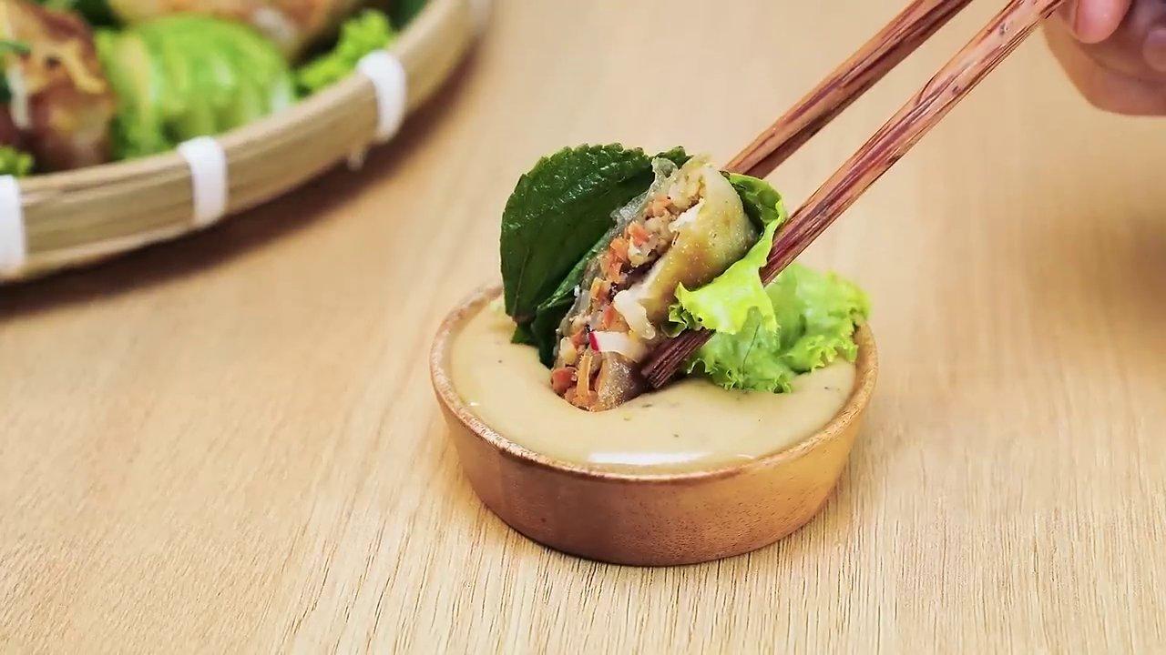 Món salad cá tươi với các loại rau sống được bày trên chiếc đá tròn, bát sốt Kewpie đặt ở trung tâm như một điểm nhấn.