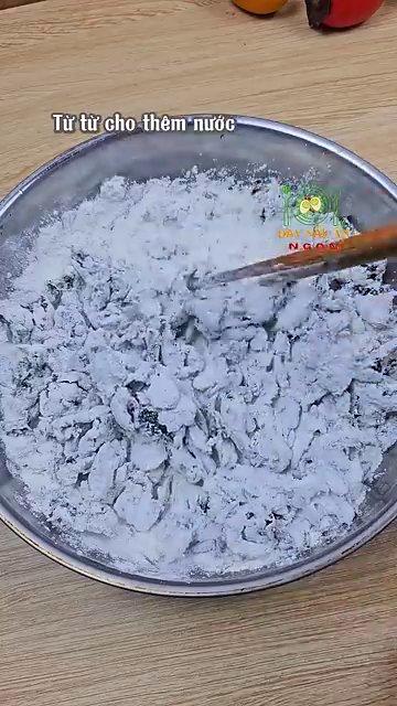 Dàn mỏng bột bánh trên tay để chuẩn bị cho nhân vào giữa.