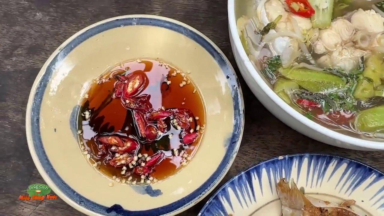 Mâm cơm gia đình với nồi cá kho tộ và tô canh chua, bốc khói nghi ngút.