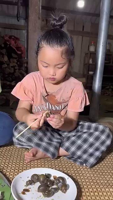 Đôi tay đang chấm ốc vào bát nước chấm chua ngọt.
